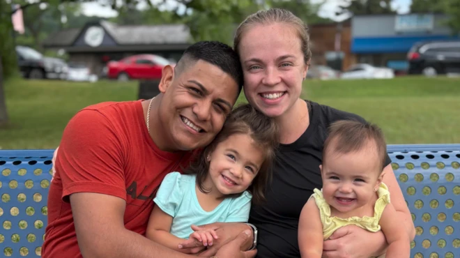 La familia Pérez sentada en una plaza. Madre, padre, y las dos niñas.