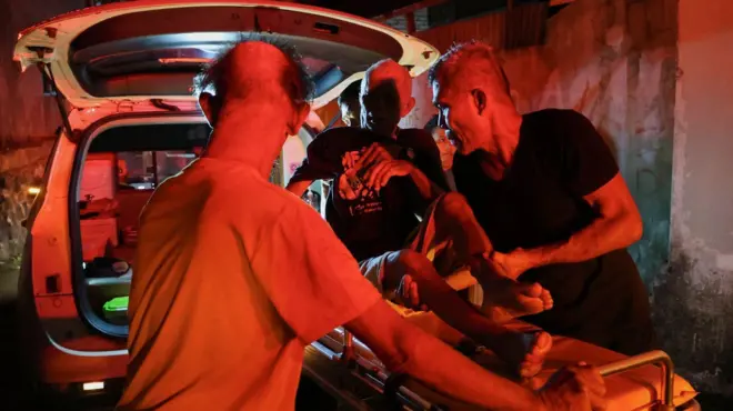 Seorang penyintas kebakaran di Panti Werdha Damai sedang dievakuasi saat kebakaran terjadi.