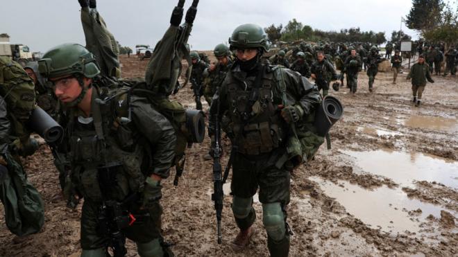Israeli soldiers prepare to enter the Gaza Strip, near the Israel-Gaza perimeter fence (13 December 2023)