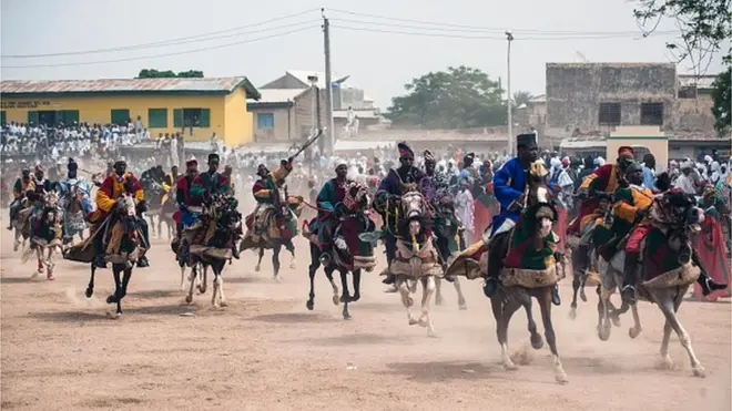 Members of the Durbar procession race di final stretch to di Emir's palace in Kano, northern Nigeria on July 6, 2016.