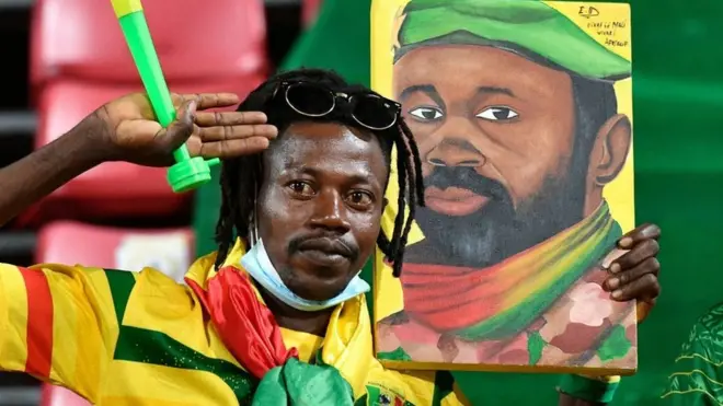 Un supporter malien tient un portrait du chef de la junte malienne, le colonel Assimi Goita, avant le match de football des huitièmes de finale de la Coupe d'Afrique des Nations (CAN) 2021 entre le Mali et la Guinée équatoriale au stade Omnisport de Limbe, le 26 janvier 2022.