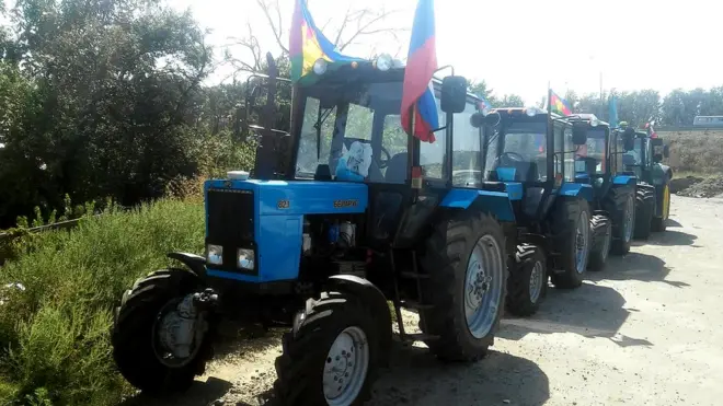 Сейчас колонна тракторов заблокирована автомобилями ДПС на стоянке в поселке Дорожный под Ростовом-на-Дону.