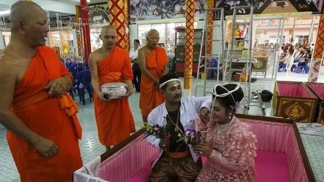 couple getting married in a coffin