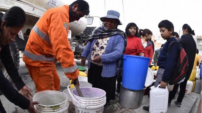 Vecinos reciben agua con cubos de camiones cisterna