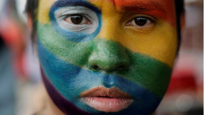 An activist with his face painted in the colours of the rainbow flag during a march in Managua, June 2018