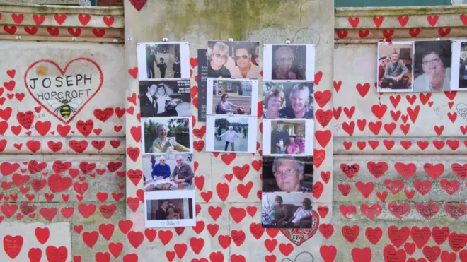 Londra'daki Covid kurbanlarını anma duvarında hastalık kaynaklı ölenlerin fotoğrafları ve çok sayıda kalp görülüyor.