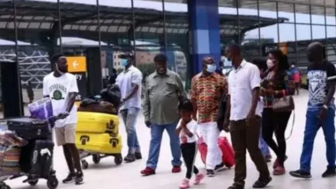 Awọn arinrinajo ọmọ Naijiria pẹlu ẹru wọn ni papakọ ofurufe, koda, ọkunrin kan mu ọmọ kekere kan dani ninu wọn