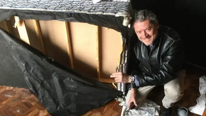 Vasileios Vasileiou junto a la cama en la que se escondió cuando los talibanes entraron en su habitación..