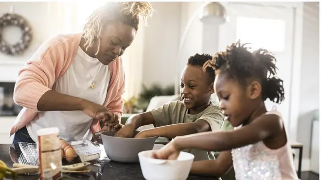 Los cambios en el cerebro de las madres pueden durar años. Una madre cocinando con su hijo e hija