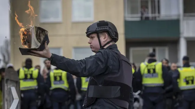 السياسي السويدي المتطرف راسموس بالودان لدى إحراقه نسخة من القرآن في استوكهولم