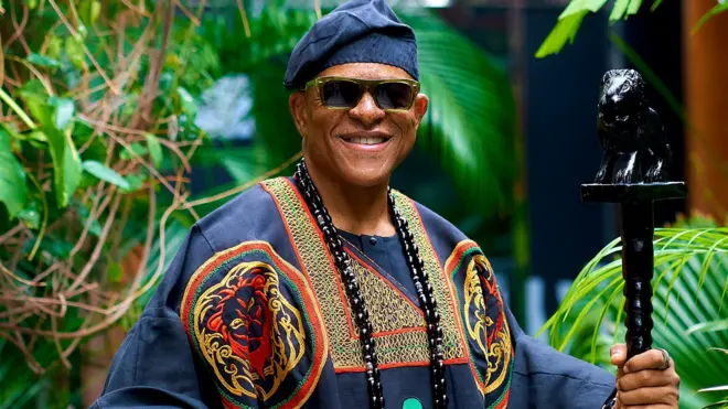 Farooq Oreagba wọ agbada ati fila, o mu ọpa lọwọ