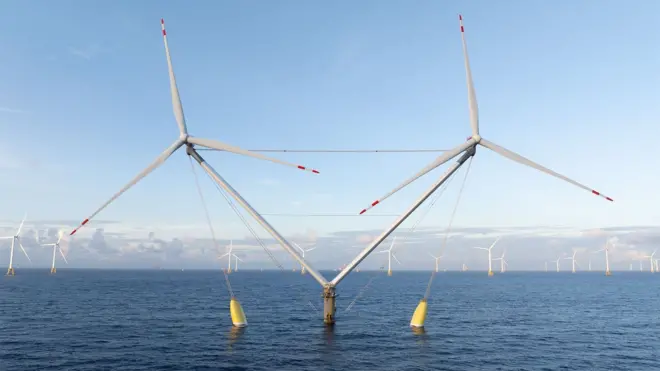 Turbinas eólicas con aspas dobles en un parque eólico marino, con el agua calmada y varias turbinas más en el fondo y un cielo azul