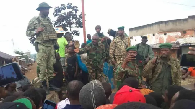 Bernard Byamungu (hagati avuga) umwe mu barwanyi bakuriye M23, arimo kuvugana n'abaturage b'ahitwa Katana ugana i Bukavu nyuma y'uko abo barwanyi bahafashe