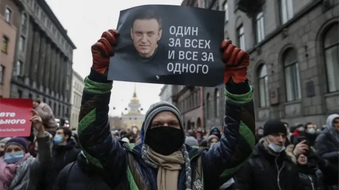 Un manifestant tient une affiche sur laquelle on peut lire "Un pour tous et tous pour un" pour soutenir le leader de l'opposition Navalny