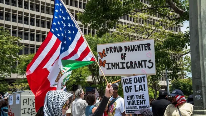 تعدادی معترض با پلاکاردها و پرچم در دست