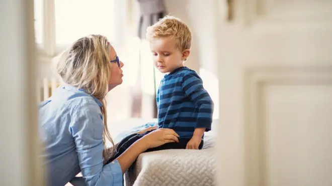 Una madre intentando tener una conversación con su pequeño hijo.