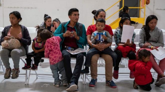 Migrants from Latin America wait to make phone calls to their family in friends who host them in the US, at a migrant centre in El Paso, Texas, April 2019