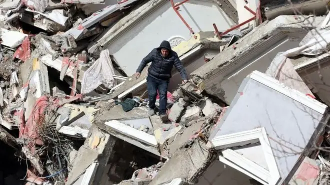 Un hombre camina entre los escombros de un edificio derrumbado en Kahramanmarash el día después de que un terremoto de 7,8 grados de magnitud azotara el sureste de Turquía.