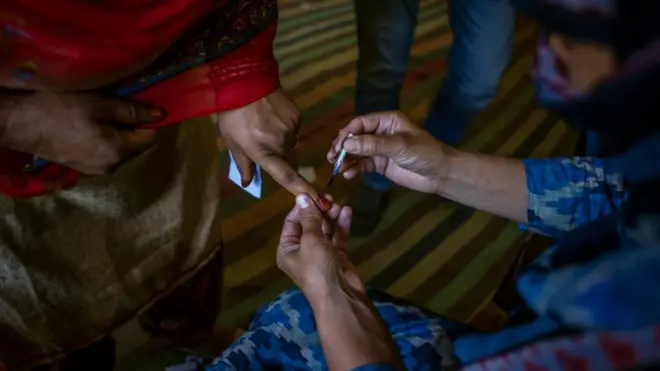 polling officer ink marks the finger of a kashmiri woman before casting her vote on the third phase of Indian general-election on April 23, 2019, in Anantnag, south of Srinagar, the summer capital of Indian administered Kashmir, India.