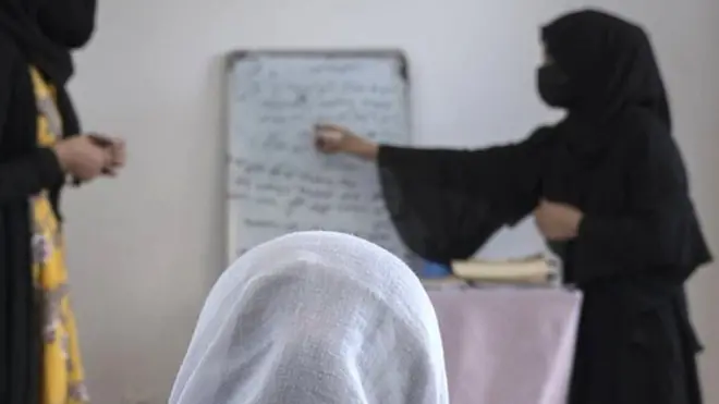 Young Afghan woman gather together for a lesson in an informal classroom