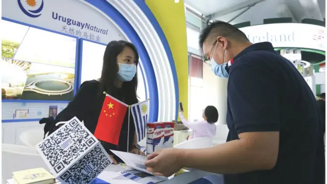 在中國國際服務貿易交易會國別和省區市專區，烏拉圭展位的工作人員（左）與參觀者交談（2020年9月資料照片）。