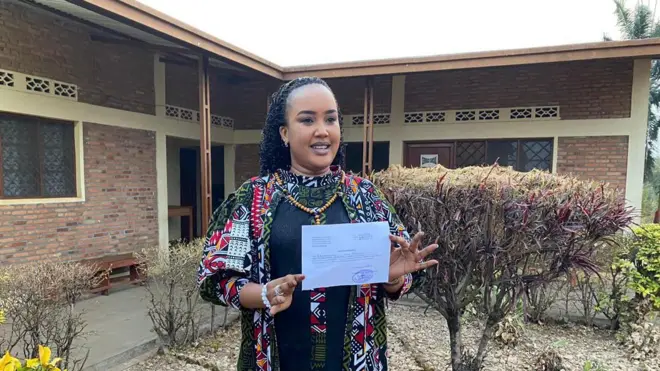 Floriane Irangagiye imbere y'ibohero rya Bubanza afise mu ntoke urupapuro rumwemerera gusohoka ibohero