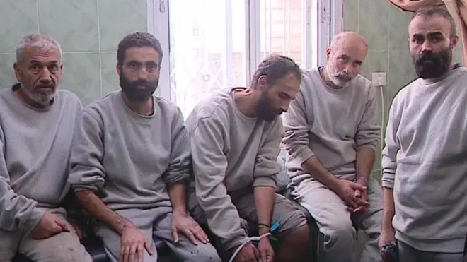 Five of the six men who say they were badly beaten sit and stand in a Rafah hospital