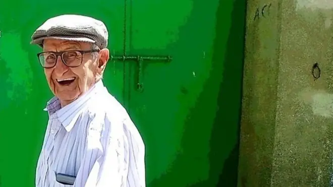 ชายชราใส่หมวกเบเล่ต์ หันมายิ้ม