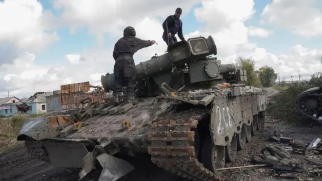 Ukrainian soldiers prepare to tow a captured Russian tank near the recently recaptured city of Kupyansk in Kharkiv's area, Ukraine, 04 October