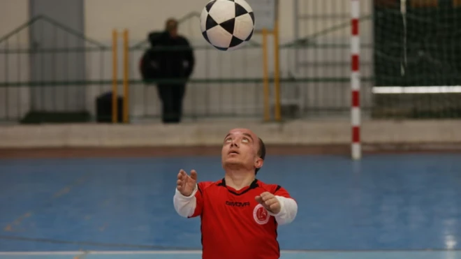 هيثم السقا يلعب كرة القدم مرتديا قميص منتتخب فلسطين الأحمر