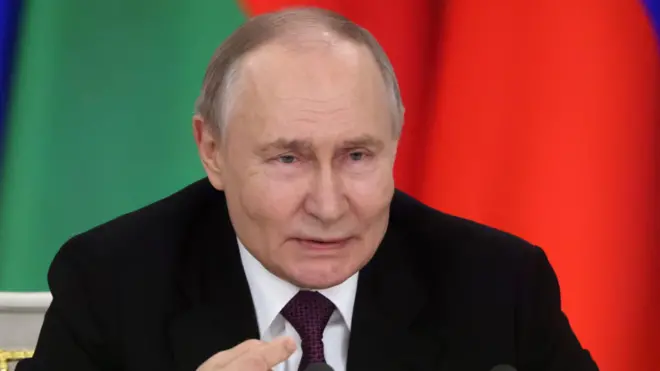 الرئيس الروسي فلاديمير بوتين يُشير بيده خلال مؤتمر صحفي في قصر الكرملين الكبير.