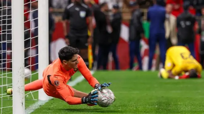 بونو أثناء تصديه للكرة. يرتدي زياً رياضياً برتقالي اللون. 