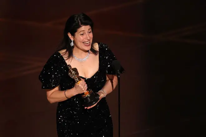 Uma mulher segurando a estatueta do Oscar