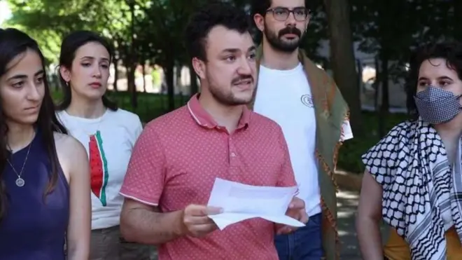 Mahmoud Khalil, rodeado por cuatro amigos, sujeta un papel en la mano. 