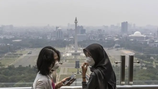 Dua perempuan mengenakan masker karena polusi udara di Jakarta, pada 10 Agustus 2023.