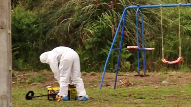 Forensic officer in garden with swings