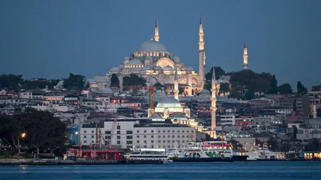 د استانبول مشهور جومات سلطان احمد د ماښام په تته رڼا کې برېښي چې څراغونه یې لګېدلي دي. شاوخوا یې نورې ودانۍ او لاندې په سمندر کې کښتۍ ولاړې برېښي.