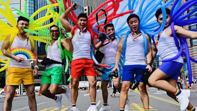 Participants jump in a pose while taking part in the annual gay pride parade in Taipei