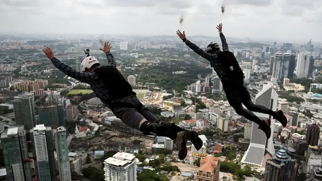 Dos hombres saltan en paracaídas.