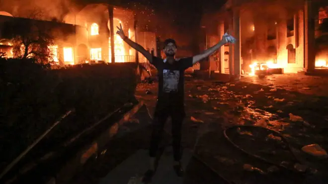 متظاهر أمام مقر القنصلية الإيرانية بالبصرة