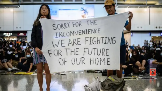 "Вибачте за незручності. Ми боремося за майбутнє нашого дому", - йдеться на плакаті демонстрантів, які зайняли аеропорт Гонконгу