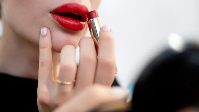 Une jeune femme appliquant du rouge à lèvres. ( Photo d'illustration.)