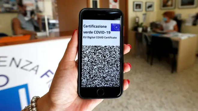 موظفة في مكتب في روما تبرز بطاقة "المرور الخضراء" الرقمية الخاصة بها