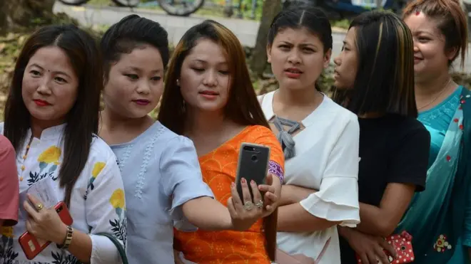 روحینی گاؤں کے پولنگ سٹیشن کے باہر خواتین سیلفی لیتے ہوئے