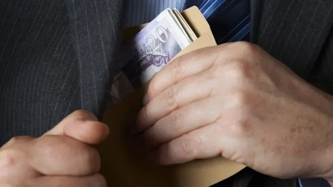 Un homme sort des billets de sa poche