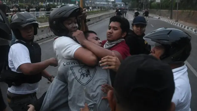Petugas kepolisian membekuk mahasiswa saat berunjuk rasa di depan gedung DPR RI, Jakarta, Selasa (24/09).