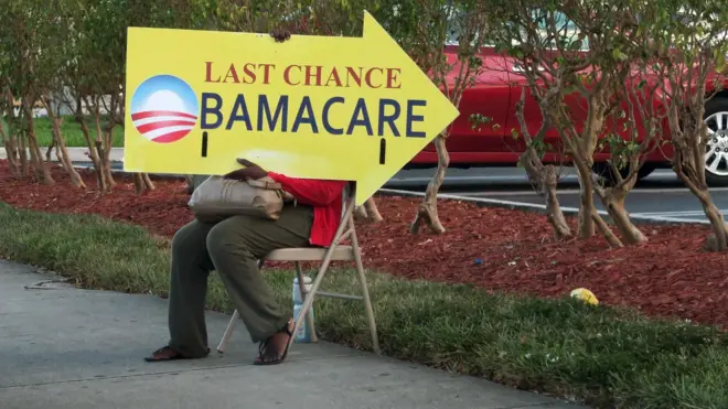 A woman holds an Obamacare sign in front of a medical centre in Miami in November 2017