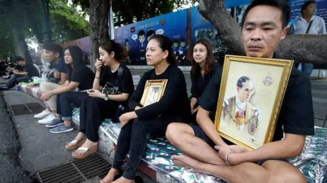 Người dân chờ đoàn xe chở linh cữu Quốc vương Bhumibol đi qua