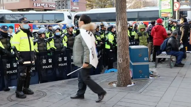 身披韩国国旗的抗议群众，不断地向警察挑衅。（BBC中文网特约记者郑仲岚摄影）