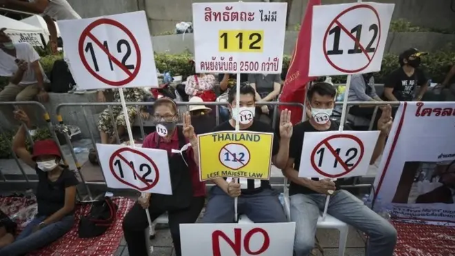 Anti-government protesters hold up placards during a rally calling to lift the section 112 of the Thai Criminal Code